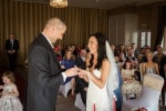 A bride and groom exchange rings during their indoor wedding ceremony at Inchydoney Island Lodge and Spa