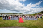 An outdoor wedding ceremony at  Inchydoney Lodge and Spa with the sea and clouds in the distance