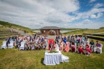 A bride and groom celebrate with their guests at the end of their outdoor wedding ceremony at  Inchydoney Lodge and Spa