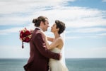 A bride and groom embrace overlooking the sea at Inchydoney Lodge and Spa