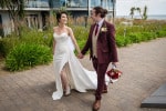 A bride and groom walk hand in hand  towards Inchydoney Lodge and Spa