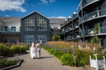A bride and groom wave to their guests while arriving at Inchydoney Island Lodge and Spa