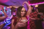 A bridesmaid dances while holding a drink at Inchydoney Island Lodge and Spa