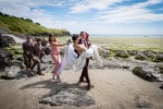 A groom carries his bride across the beach at Inchydoney Island Lodge and Spa