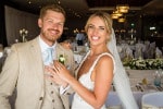 A bride and groom show their wedding rings in the dining room of Inchydoney Island Lodge and Spa
