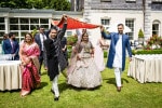 An Indian bride is accompanied to her wedding ceremony by her family who are holding a cloth above her. It is called the kanyadaan