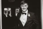 A black and white photo of a groom standing outside the Maryborough hotel and Spa