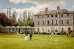 A newly married couple walk across the lawn of the Maryborough House Hotel