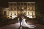 A bride and groom stand backlit at night outside the Maryborough hotel and Spa in Cork on their wedding day